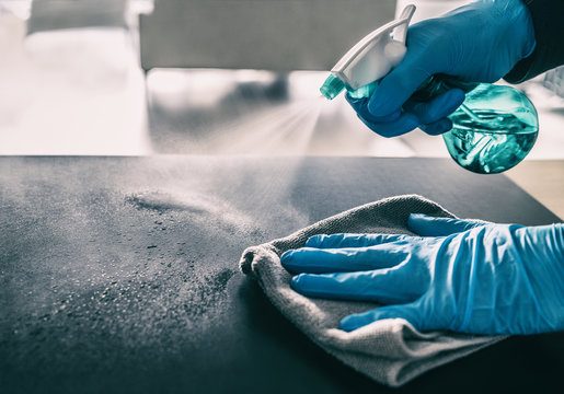 Wiping a surface with disinfectant spray